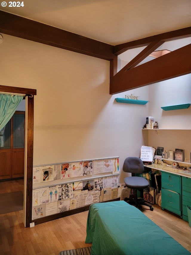 bedroom with hardwood / wood-style flooring and beamed ceiling