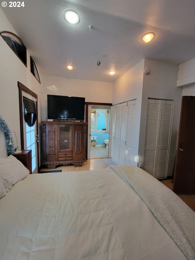 bedroom featuring a textured ceiling and multiple closets