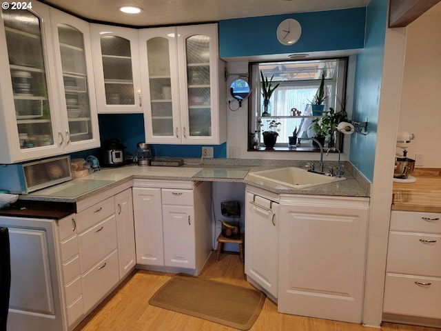 kitchen featuring light hardwood / wood-style flooring, white cabinetry, and sink