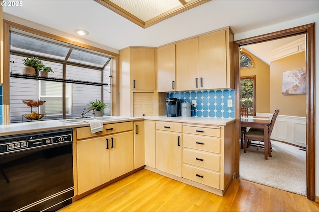 kitchen featuring crown molding, sink, light hardwood / wood-style flooring, black dishwasher, and light brown cabinetry