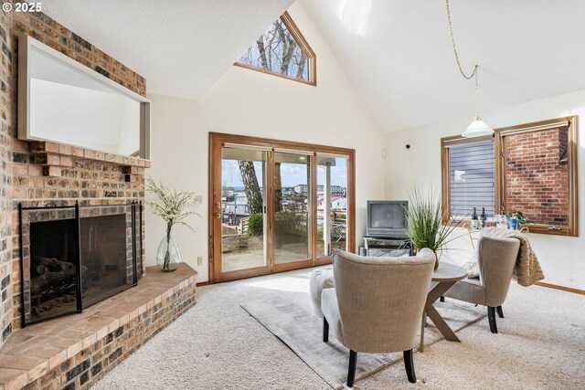 living room with a brick fireplace, carpet, and high vaulted ceiling