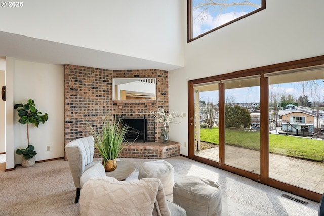 carpeted living room with a brick fireplace