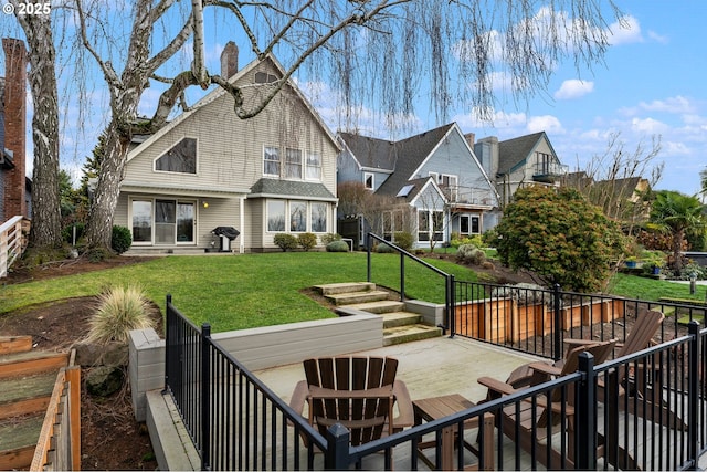 back of house with a wooden deck and a lawn