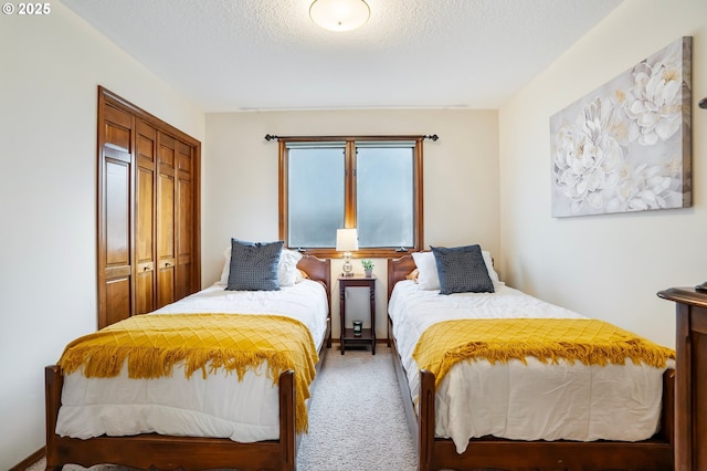 carpeted bedroom featuring a textured ceiling and a closet