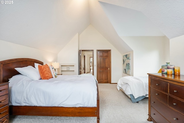 carpeted bedroom with a textured ceiling and vaulted ceiling