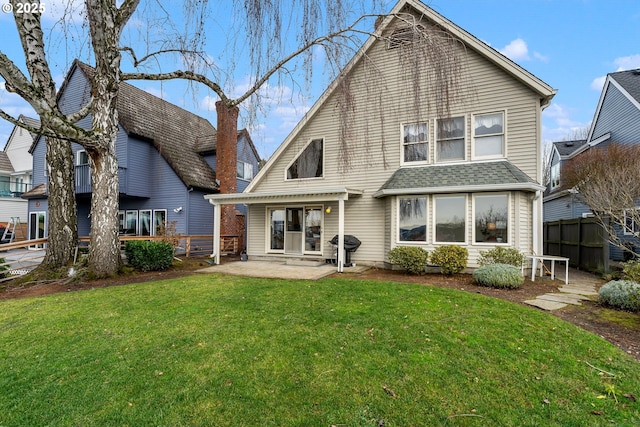 back of property with a yard and a patio area