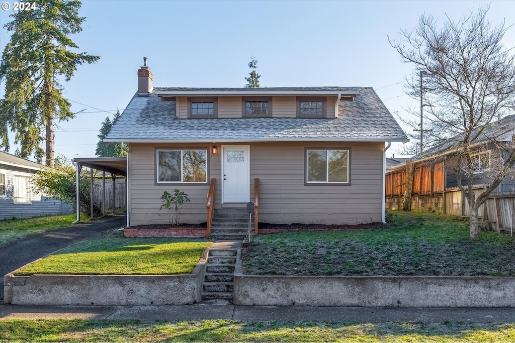 bungalow with a front yard and a carport