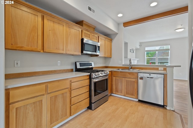 kitchen with sink, light hardwood / wood-style flooring, appliances with stainless steel finishes, beam ceiling, and kitchen peninsula