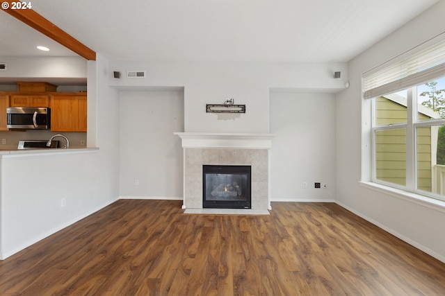 unfurnished living room with a fireplace and dark hardwood / wood-style floors