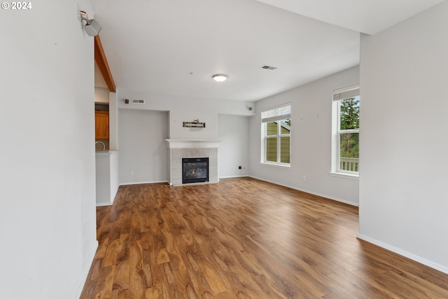 unfurnished living room featuring a fireplace and wood-type flooring