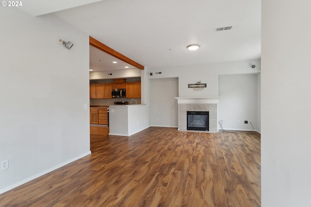 unfurnished living room featuring a fireplace and dark hardwood / wood-style flooring