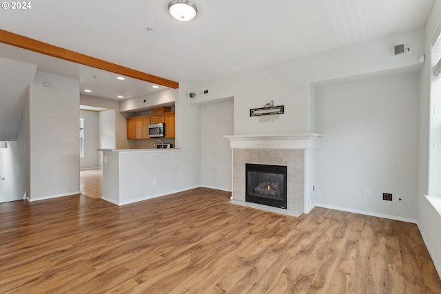 unfurnished living room with a fireplace and light hardwood / wood-style floors