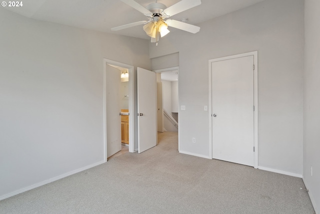 unfurnished bedroom with ensuite bath, ceiling fan, and light carpet