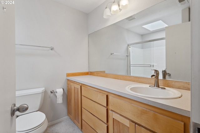 bathroom featuring vanity, toilet, an enclosed shower, and a skylight