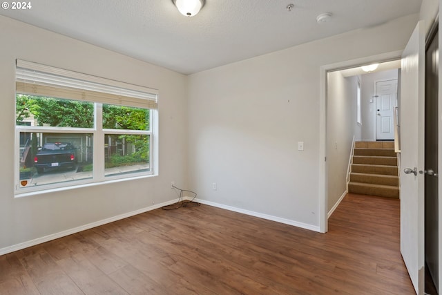 empty room with a textured ceiling and hardwood / wood-style flooring