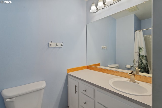 bathroom with vanity, toilet, and curtained shower