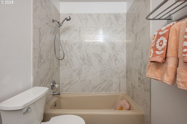 bathroom with tiled shower / bath and toilet