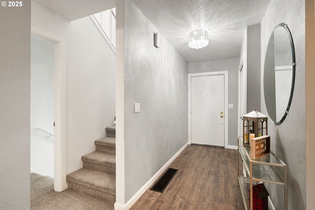 entrance foyer featuring a chandelier, hardwood / wood-style floors, and a textured ceiling