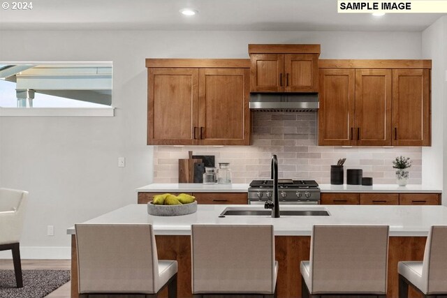 kitchen featuring backsplash, sink, hardwood / wood-style floors, and extractor fan