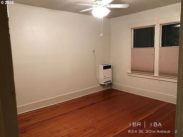 unfurnished room with heating unit, wood-type flooring, and ceiling fan