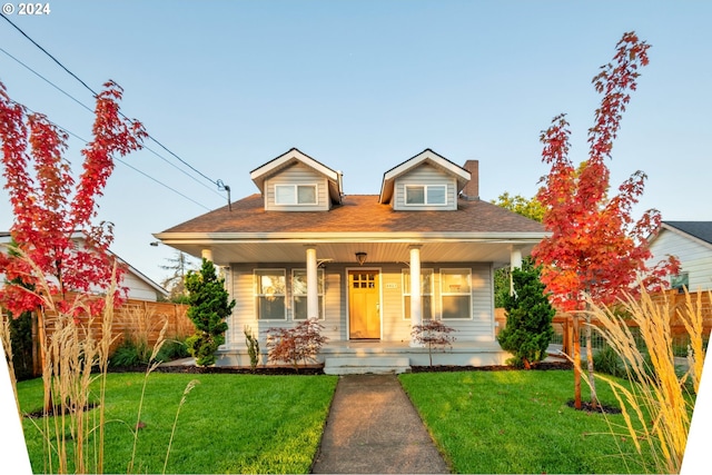 bungalow-style house with a front yard and covered porch