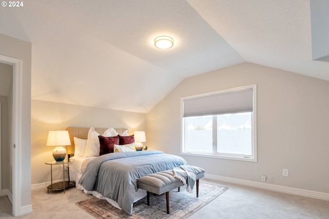 carpeted bedroom with a textured ceiling and vaulted ceiling