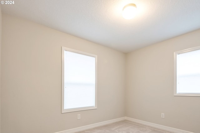 carpeted spare room with a textured ceiling