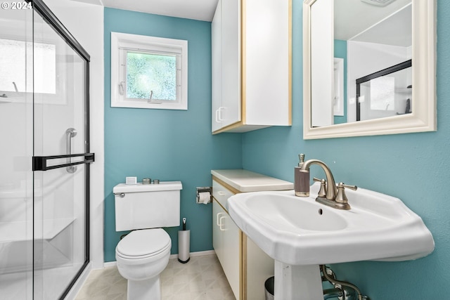 bathroom with walk in shower, sink, and toilet