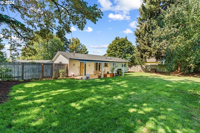 back of house with a yard and a patio