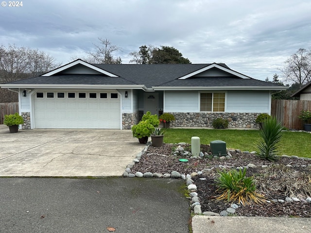 single story home with a garage and a front lawn