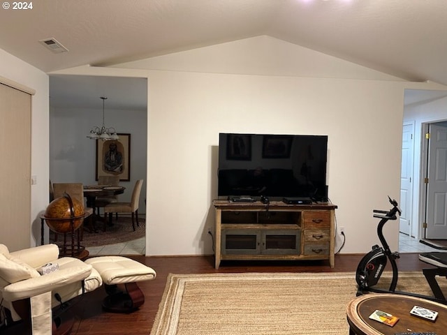 living room with wood-type flooring, lofted ceiling, and a notable chandelier