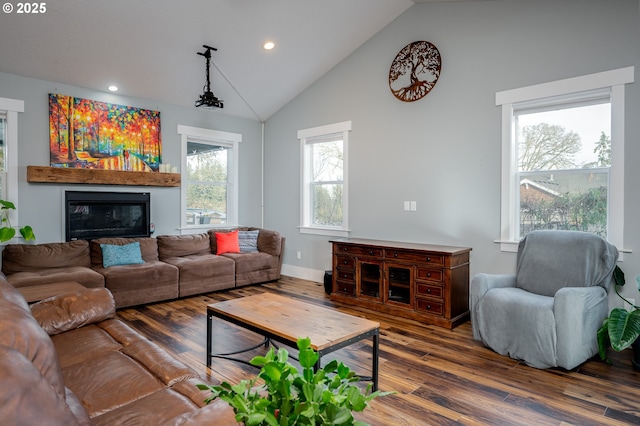 living room featuring vaulted ceiling, a healthy amount of sunlight, and dark wood-type flooring