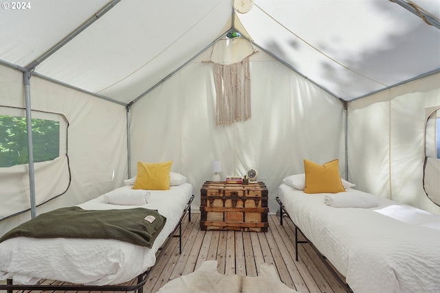 bedroom with wood-type flooring and vaulted ceiling