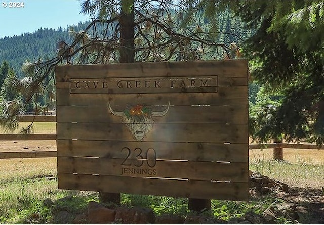 community sign with a forest view and fence