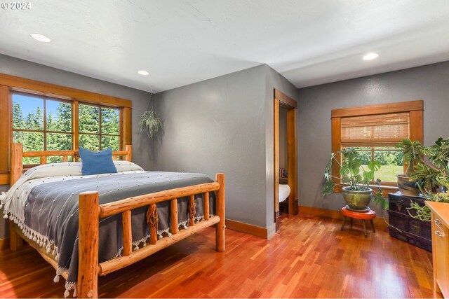 bedroom with wood-type flooring and multiple windows