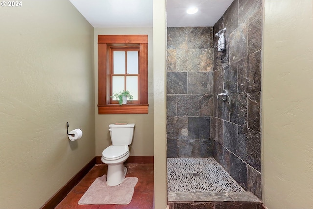 bathroom featuring a tile shower and toilet