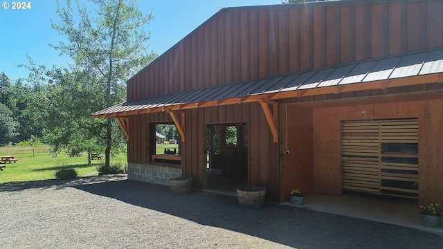 view of property exterior with metal roof, a standing seam roof, and a lawn