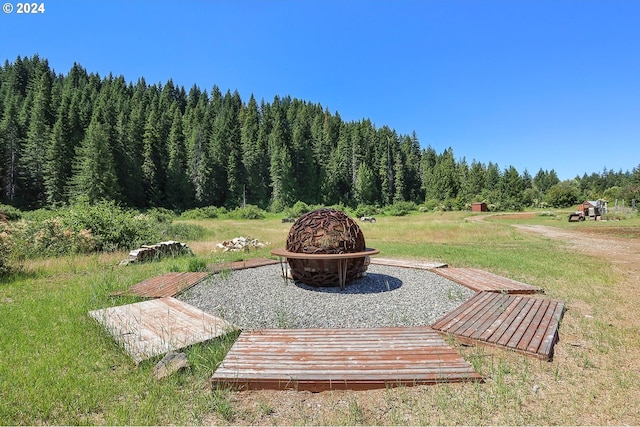 view of community featuring an outdoor fire pit and a lawn