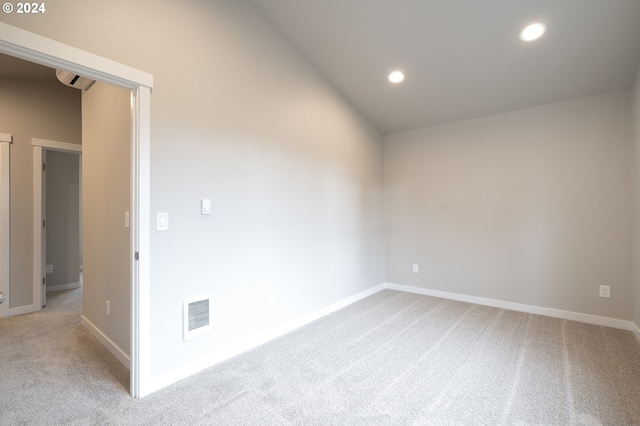 carpeted empty room with vaulted ceiling