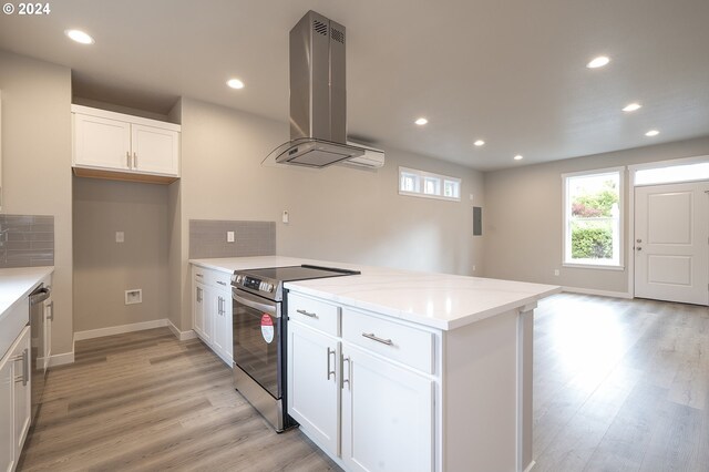 kitchen featuring appliances with stainless steel finishes, light hardwood / wood-style floors, white cabinets, and extractor fan