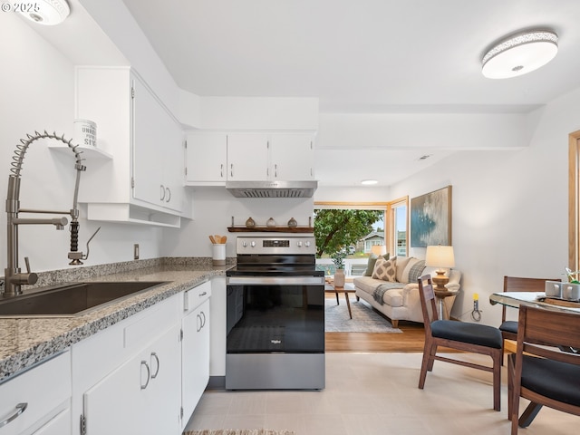 kitchen featuring electric stove, light stone counters, white cabinetry, and sink