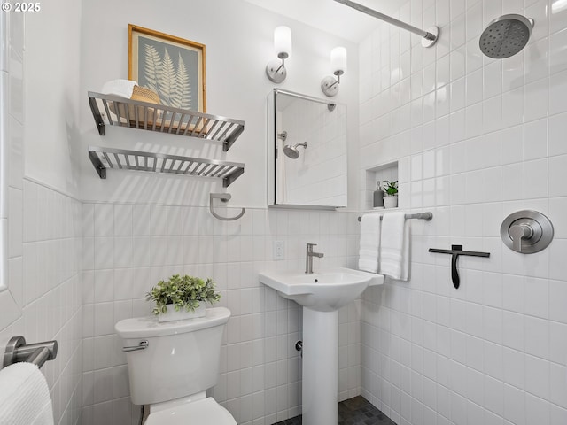 bathroom featuring toilet, tile walls, and a tile shower