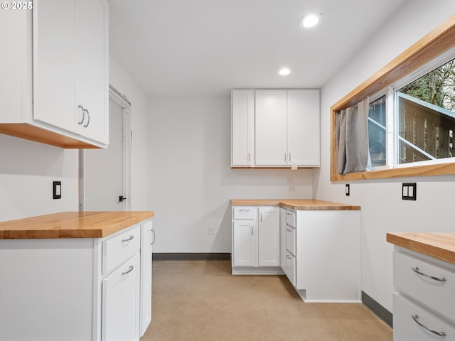 kitchen featuring butcher block counters and white cabinets