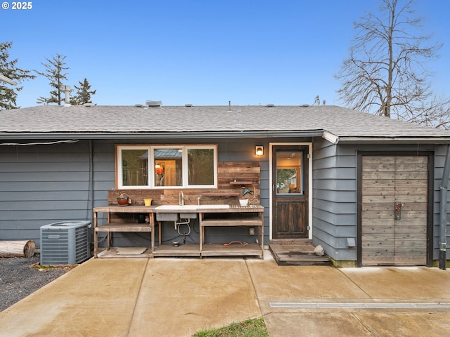 back of property with sink, a patio area, and central air condition unit