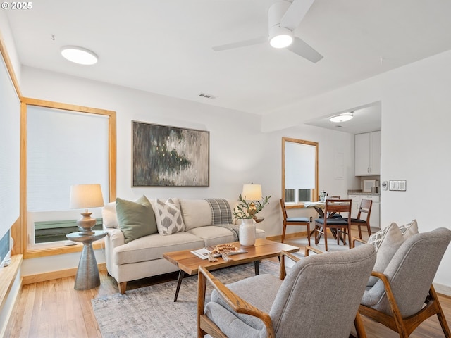 living room with ceiling fan and light wood-type flooring