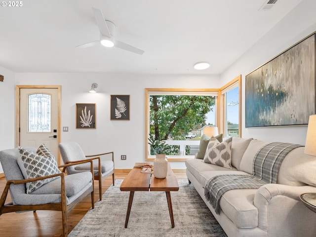 living room featuring ceiling fan and hardwood / wood-style floors