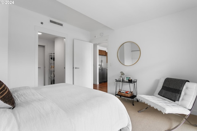 bedroom featuring stainless steel refrigerator with ice dispenser