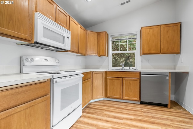 kitchen with lofted ceiling, sink, light hardwood / wood-style floors, and white appliances