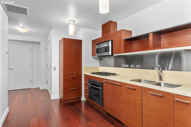 kitchen featuring appliances with stainless steel finishes, dark hardwood / wood-style flooring, and sink