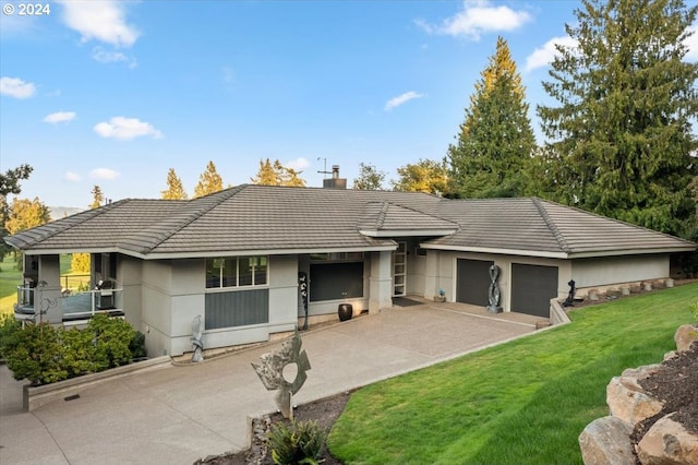 ranch-style home featuring a front lawn and a garage